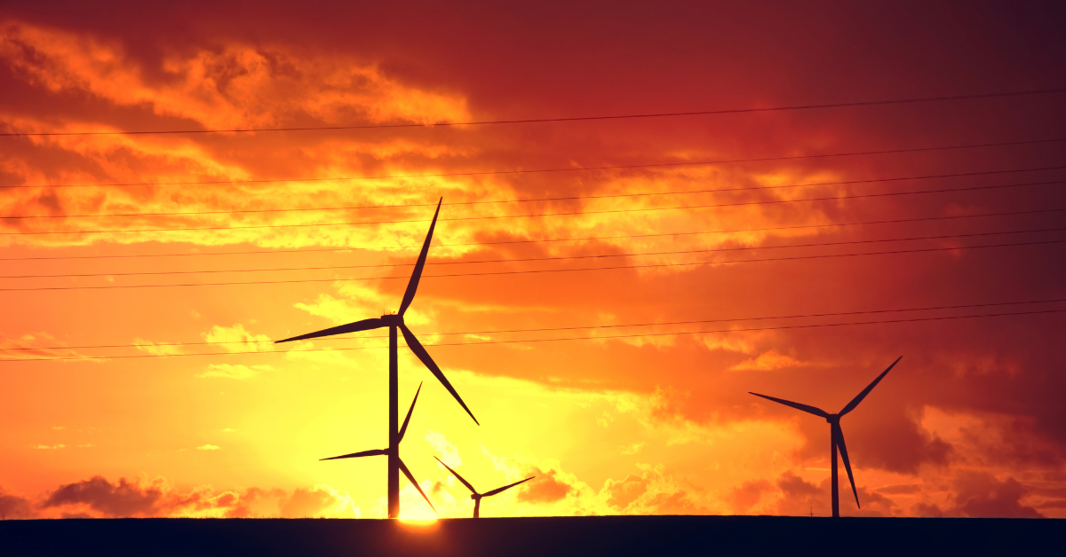 Wind turbines at sunset, symbolizing renewable energy solutions in India, including wind power and sustainable development.